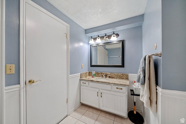 1376 Granada Dr, Bountiful, UT 84010 - bathroom featuring vanity, a textured ceiling, tile patterned floors, and wainscoting