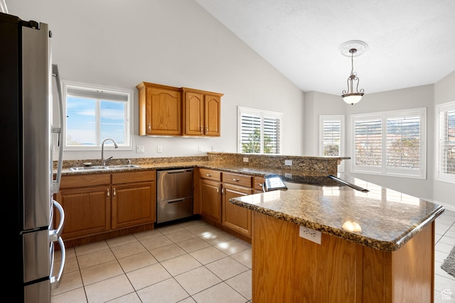 208 N Guidelight Dr, Cedar City, UT 84720 - kitchen with vaulted ceiling, a sink, a peninsula, brown cabinetry, and stainless steel appliances
