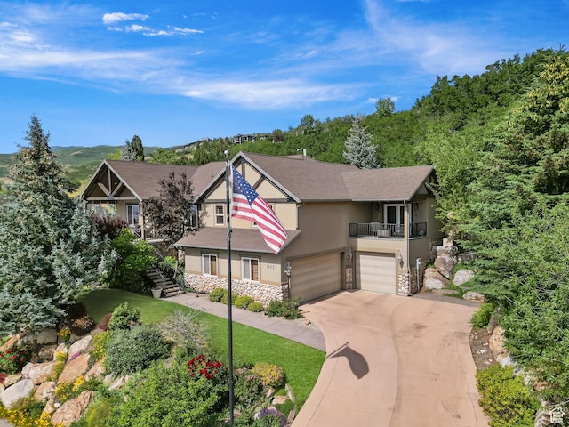 1603 E Millbrook Way, Bountiful, UT 84010 - view of front of house featuring stucco siding, a balcony, stone siding, an attached garage, and stairs