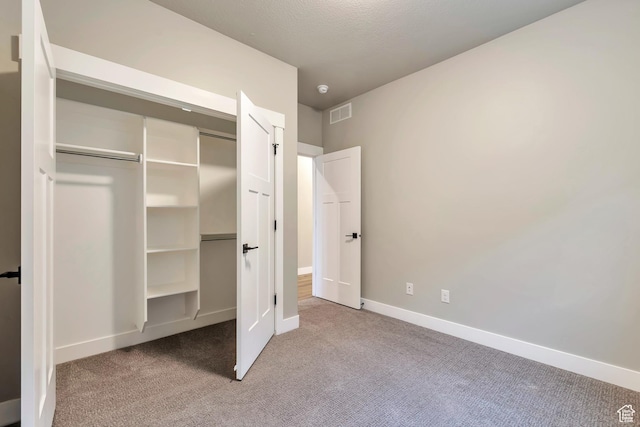 3240 W Oxford Loop Unit 219, Mountain Green, UT 84050 - unfurnished bedroom featuring a closet, carpet, baseboards, and visible vents