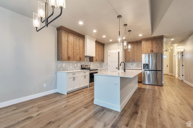 3240 W Oxford Loop Unit 219, Mountain Green, UT 84050 - kitchen featuring light countertops, light wood-type flooring, stainless steel appliances, a chandelier, and a sink