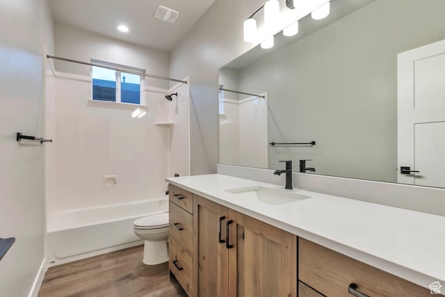 3240 W Oxford Loop Unit 219, Mountain Green, UT 84050 - bathroom featuring visible vents, washtub / shower combination, wood finished floors, toilet, and vanity