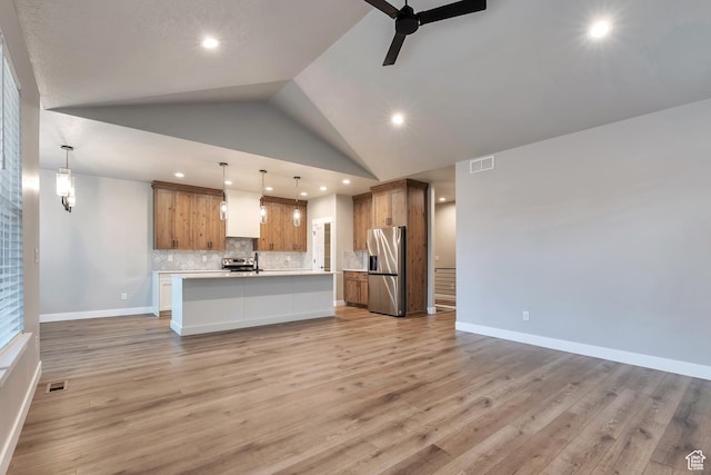 3240 W Oxford Loop Unit 219, Mountain Green, UT 84050 - kitchen featuring brown cabinets, a ceiling fan, tasteful backsplash, stainless steel refrigerator with ice dispenser, and open floor plan