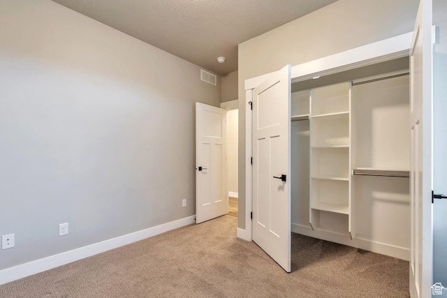 3240 W Oxford Loop Unit 219, Mountain Green, UT 84050 - unfurnished bedroom featuring baseboards, visible vents, a closet, and carpet flooring