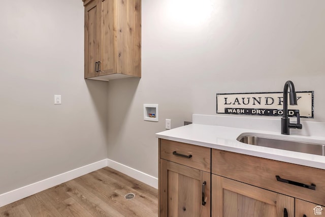 3240 W Oxford Loop Unit 219, Mountain Green, UT 84050 - laundry room with hookup for a washing machine, baseboards, a sink, light wood finished floors, and cabinet space
