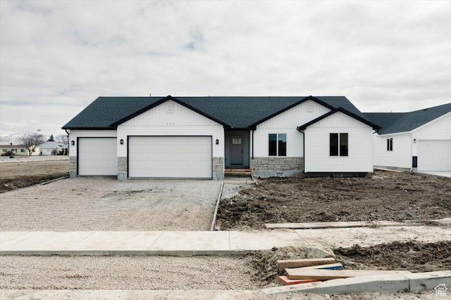 view of front of home with stone siding, a garage, concrete driveway, board and batten siding, and a shingled roof