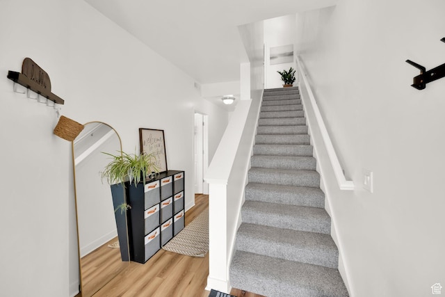 stairs featuring wood finished floors and baseboards