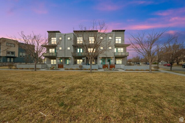 view of front of home with a front lawn and a balcony