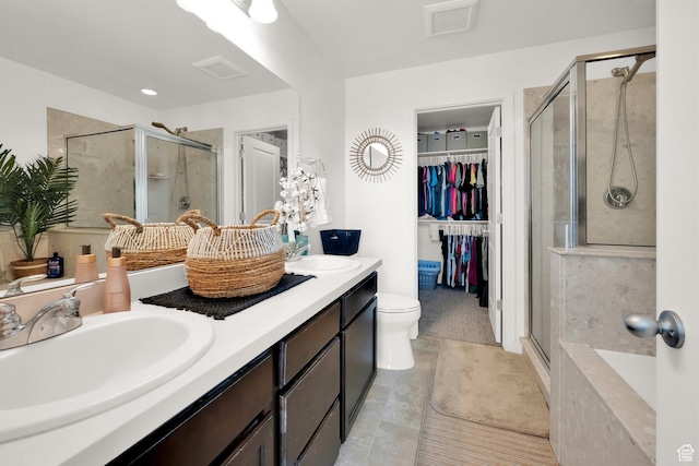 bathroom featuring a sink, a spacious closet, double vanity, and a stall shower