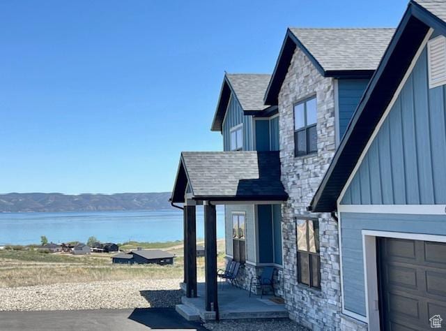 650 Blue Sage Dr, Fish Haven, ID 83287 - view of side of home featuring stone siding, board and batten siding, a shingled roof, and a water and mountain view