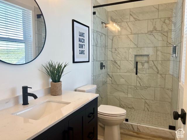 650 Blue Sage Dr, Fish Haven, ID 83287 - bathroom with toilet, vanity, a stall shower, and wood finished floors