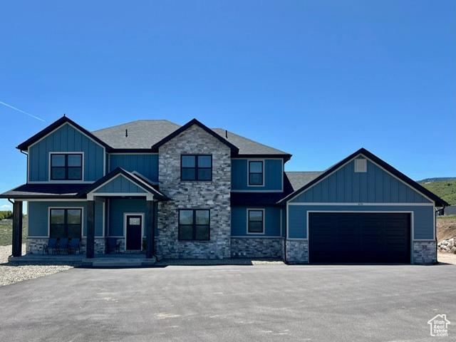 craftsman inspired home with stone siding, board and batten siding, and a porch