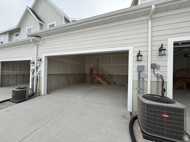 garage featuring central air condition unit and driveway