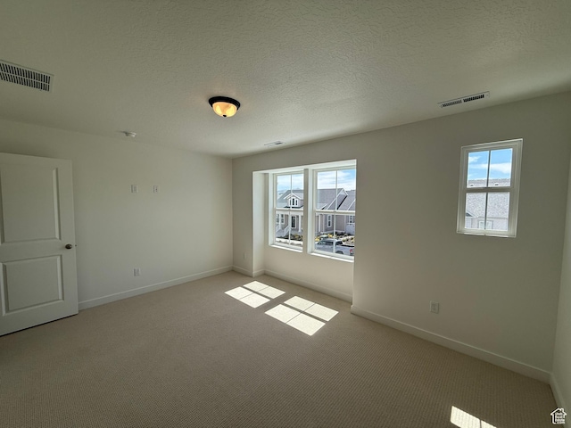 unfurnished room featuring light carpet, baseboards, and visible vents