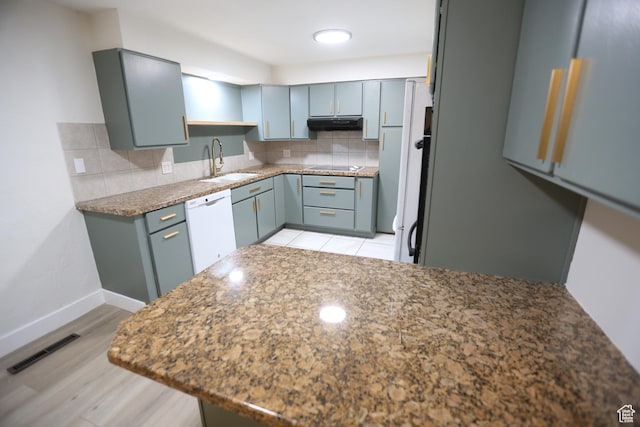 kitchen featuring a sink, backsplash, dishwasher, black electric cooktop, and visible vents