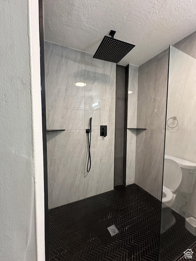 full bath with a textured ceiling, toilet, tile patterned flooring, and walk in shower