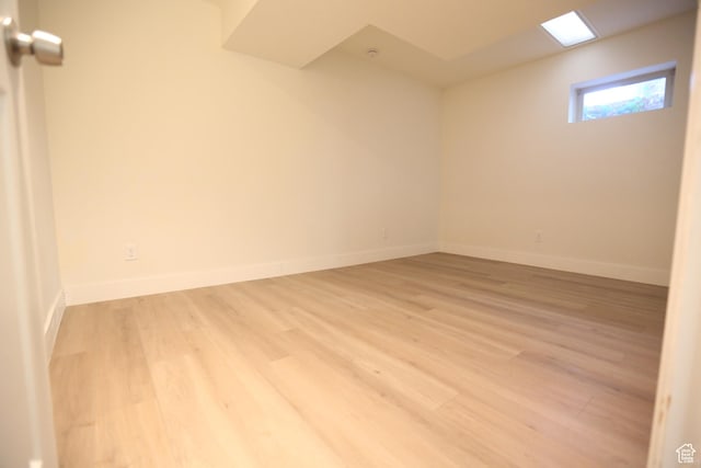 spare room featuring baseboards and light wood finished floors