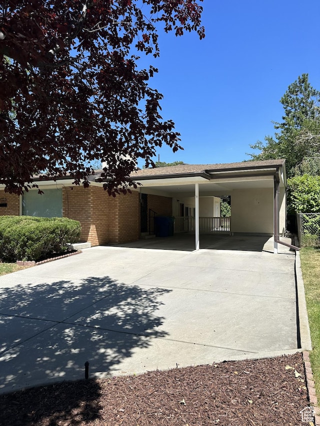view of home's exterior with an attached carport, brick siding, and concrete driveway