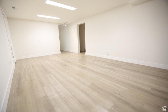 spare room featuring baseboards, visible vents, and light wood-type flooring