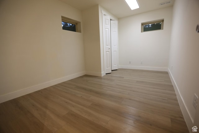 unfurnished room featuring baseboards, light wood-style floors, and visible vents