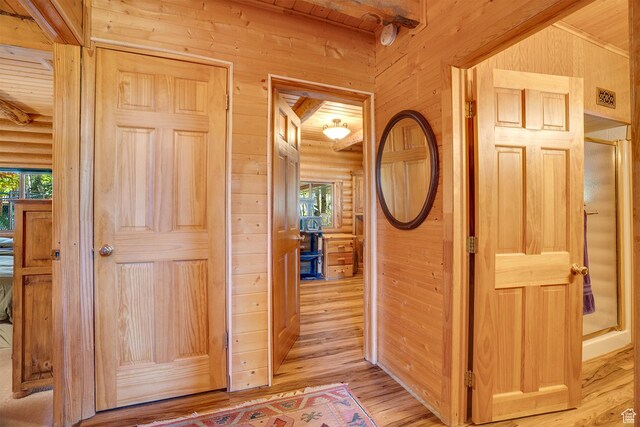 4547 Fawn Way Unit 2050, Heber City, UT 84032 - hallway featuring rustic walls, a healthy amount of sunlight, light wood-style floors, and wooden walls