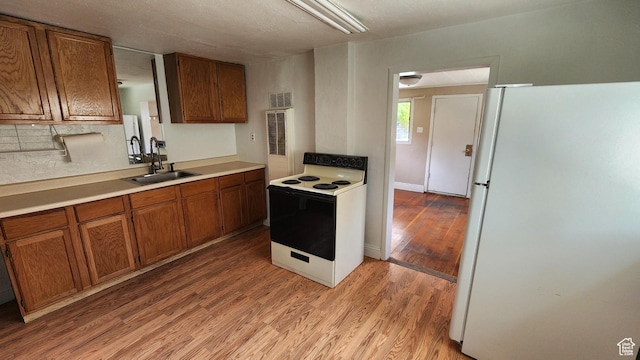 488 S 100 W, Price, UT 84501 - kitchen with white appliances, a sink, brown cabinets, light wood finished floors, and light countertops