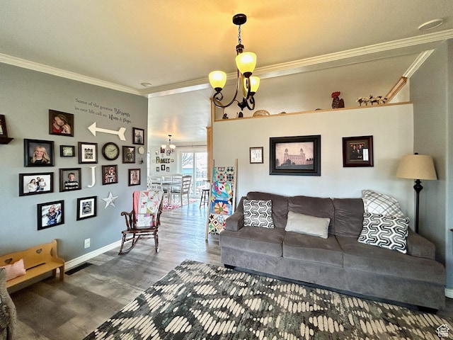 living room featuring crown molding, baseboards, a chandelier, and wood finished floors