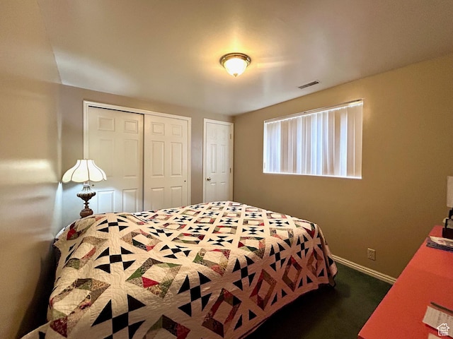 bedroom with dark carpet, baseboards, a closet, and visible vents