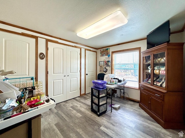 office with a textured ceiling, ornamental molding, and light wood-type flooring