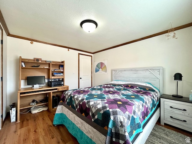 bedroom with wood finished floors, ornamental molding, and a textured ceiling