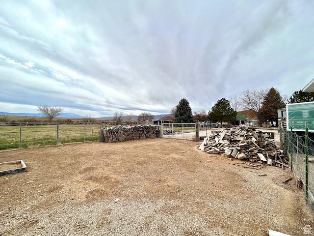 view of yard featuring fence and a rural view