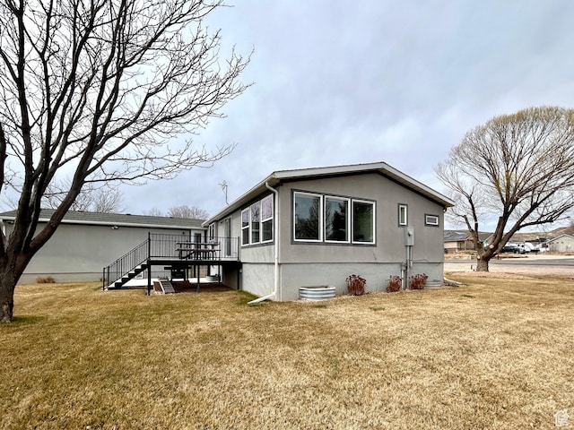 view of side of property with stairs, a deck, and a yard