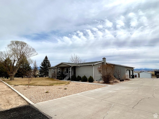 view of front of home with stucco siding, an outbuilding, and a garage