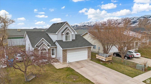 495 W 1330 N, Logan, UT 84341 - traditional home with driveway, roof with shingles, brick siding, a mountain view, and a garage