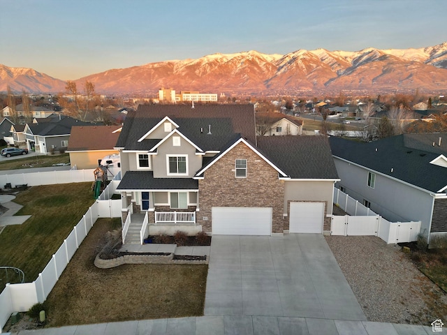 681 S Vance Dr W, Layton, UT 84041 - view of front facade with a mountain view, a fenced backyard, stone siding, and a residential view
