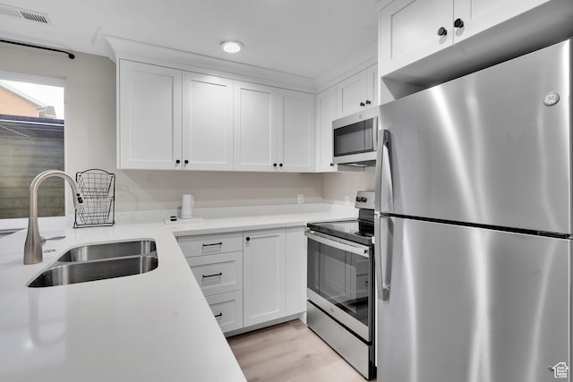 681 S Vance Dr W, Layton, UT 84041 - kitchen featuring stainless steel appliances, a sink, light countertops, white cabinets, and light wood-style floors