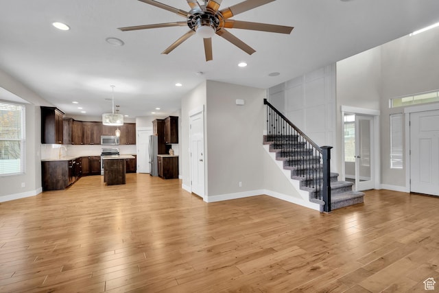 681 S Vance Dr W, Layton, UT 84041 - unfurnished living room with stairway, light wood finished floors, ceiling fan, a sink, and recessed lighting