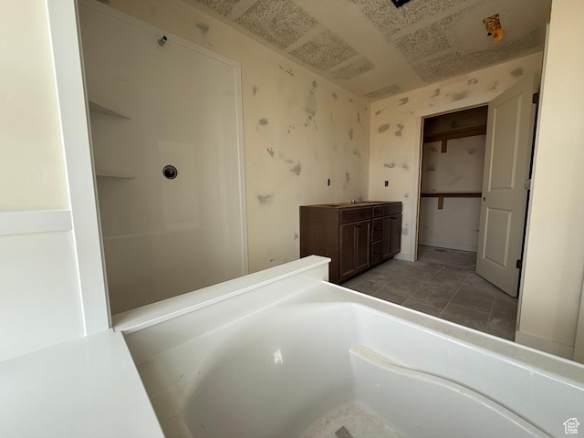 full bath featuring a tub and wallpapered walls