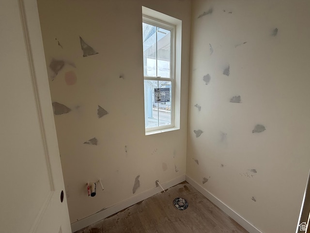 laundry area featuring light wood-style flooring and baseboards