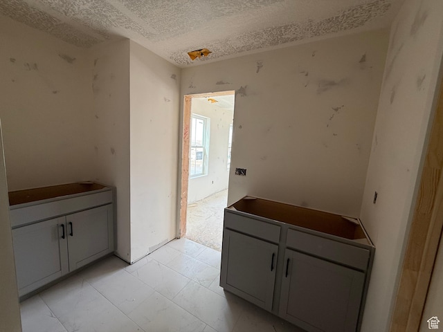 interior space with marble finish floor and a textured ceiling