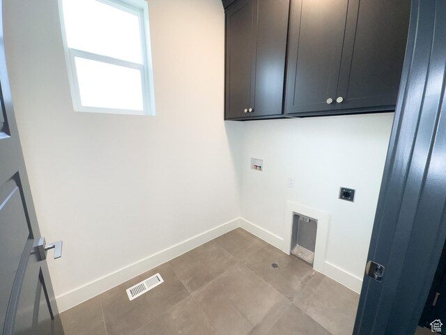 clothes washing area featuring washer hookup, electric dryer hookup, tile patterned flooring, visible vents, and cabinet space