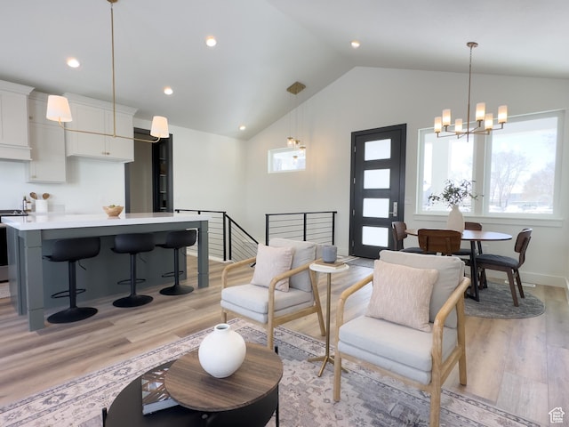 living room featuring vaulted ceiling, recessed lighting, baseboards, a chandelier, and light wood finished floors