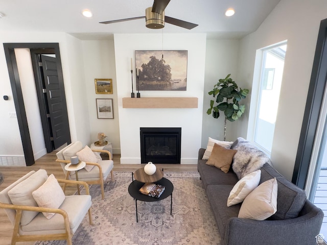 living area featuring baseboards, wood finished floors, ceiling fan, and recessed lighting