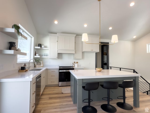 kitchen with vaulted ceiling, open shelves, stainless steel appliances, a center island, and a sink