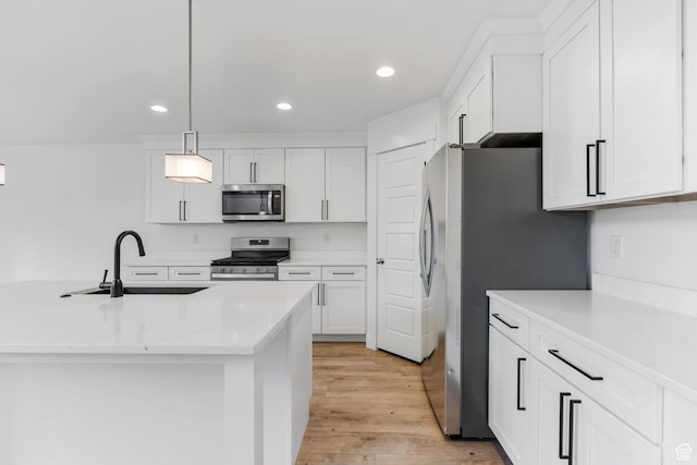 951 W Cushing Rd, Bluffdale, UT 84065 - kitchen featuring white cabinets, light wood finished floors, stainless steel appliances, a sink, and hanging light fixtures