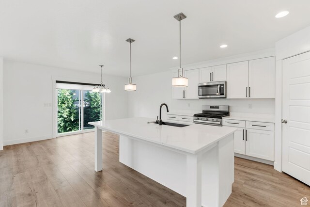951 W Cushing Rd, Bluffdale, UT 84065 - kitchen featuring a kitchen island with sink, appliances with stainless steel finishes, white cabinetry, a sink, and light wood-type flooring