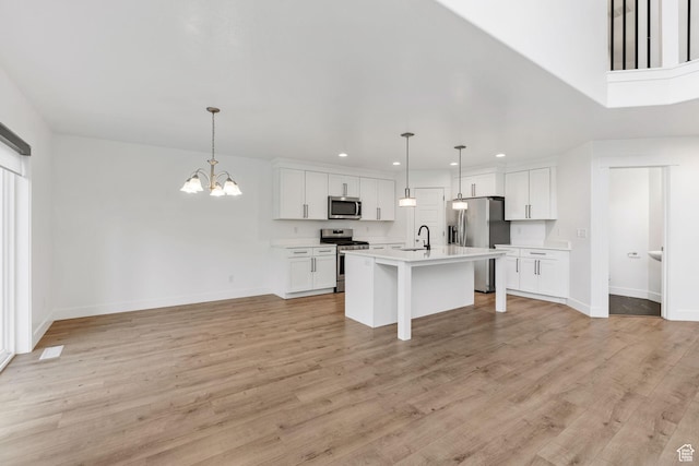 951 W Cushing Rd, Bluffdale, UT 84065 - kitchen with open floor plan, light countertops, an inviting chandelier, a sink, and appliances with stainless steel finishes
