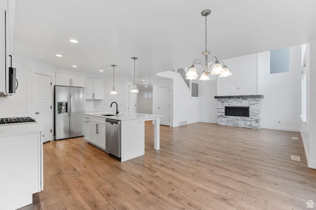 951 W Cushing Rd, Bluffdale, UT 84065 - kitchen featuring light wood-style flooring, appliances with stainless steel finishes, a sink, open floor plan, and a notable chandelier