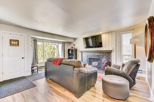 1637 Village Round Dr Unit 8, Park City, UT 84098 - living area featuring a stone fireplace, baseboards, light wood-style flooring, and a textured ceiling