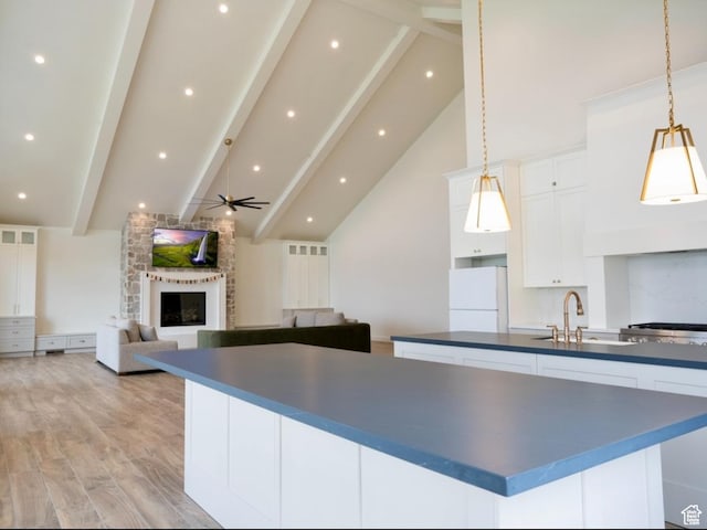 kitchen featuring dark countertops, a spacious island, a sink, and freestanding refrigerator